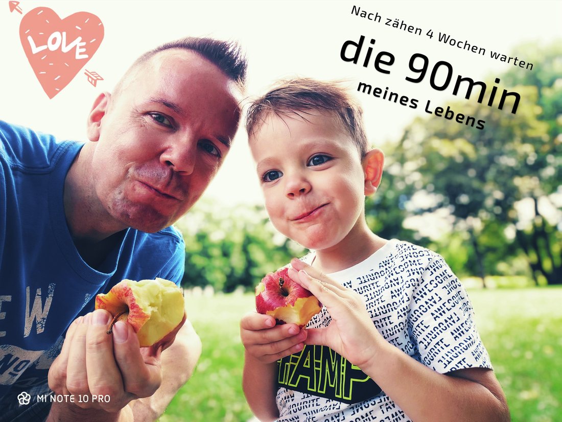 Der Vater und sein Sohn im Park, beide mit einem angebissenen Apfel in der Hand